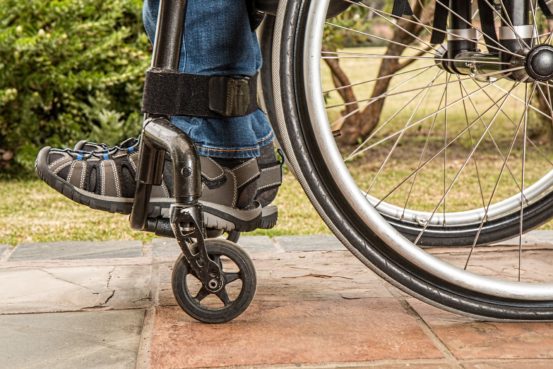Shoes and wheels of person in wheelchair